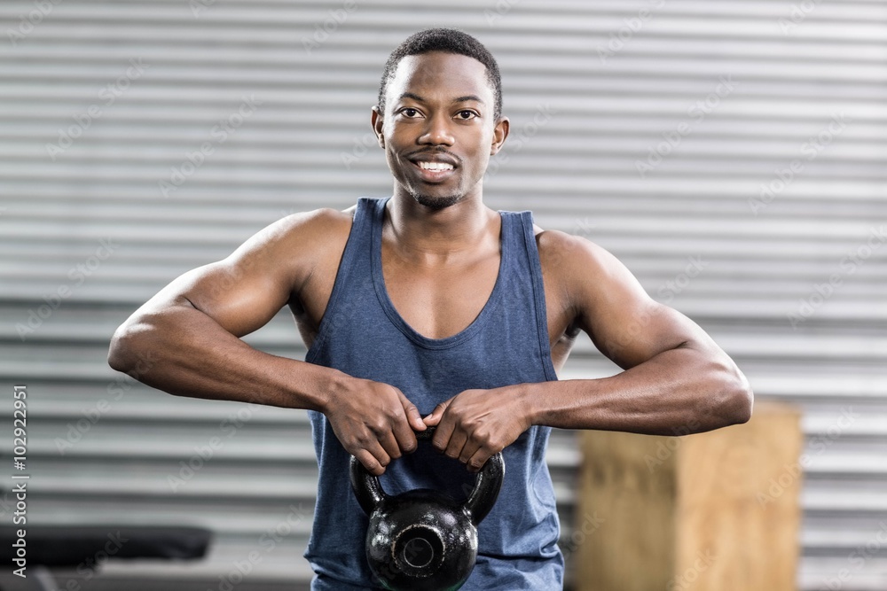 Fototapeta premium Portrait of fit man lifting dumbbells