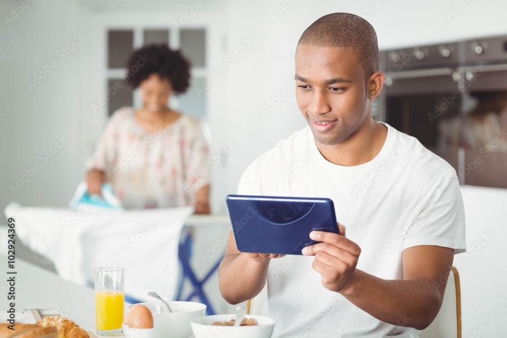Young man using tablet in kitchen Young man using tablet in kitchen