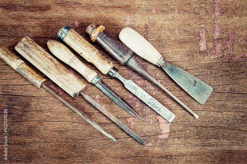 Old vintage rusty carpenter tools on grunge wooden background in vintage style
