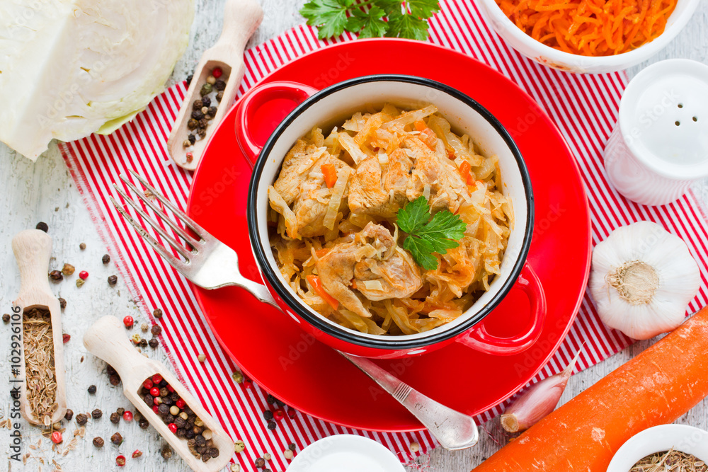 Braised cabbage with meat and carrot in a red bowl Braised cabbage with meat and carrot in a red bowl