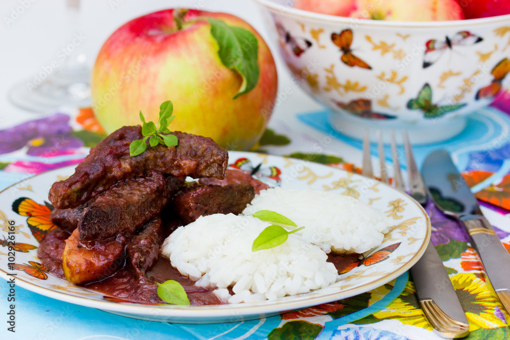 Liver with apples in red wine sauce with rice garnish. Useful and tasty dishes for lunch. Selective focus