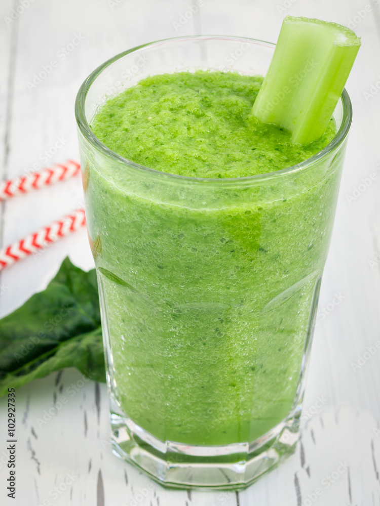Green smoothie with celery, cucumber, spinach, apple and lemon on a white wooden table Green smoothie with celery, cucumber, spinach, apple and lemon on a white wooden table