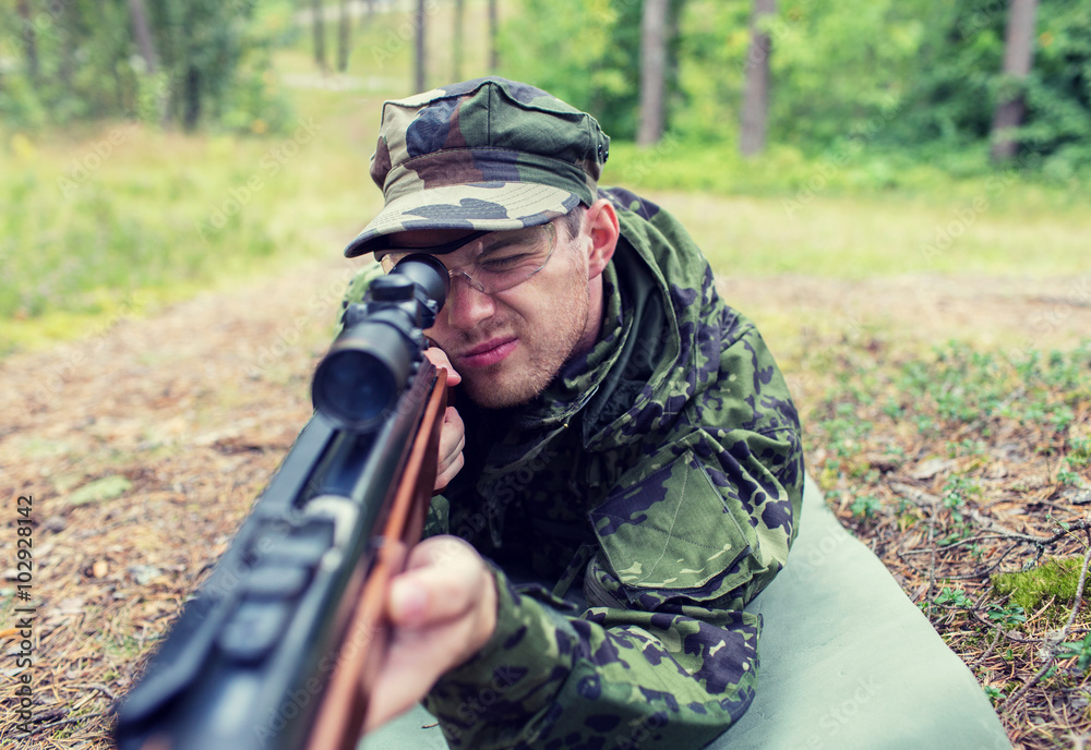 close up of soldier or hunter with gun in forest close up of soldier or hunter with gun in forest