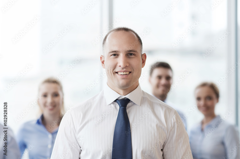 smiling businessman with colleagues in office smiling businessman with colleagues in office
