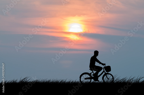 silhouette of the cyclist on road bike at sunset