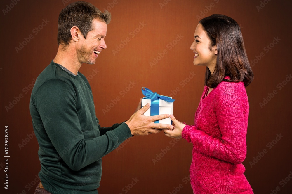 Composite image of girlfriend taking gift from boyfriend Composite image of girlfriend taking gift from boyfriend