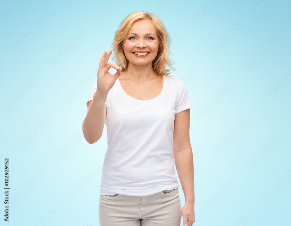 happy woman in white t-shirt showing ok hand sign happy woman in white t-shirt showing ok hand sign