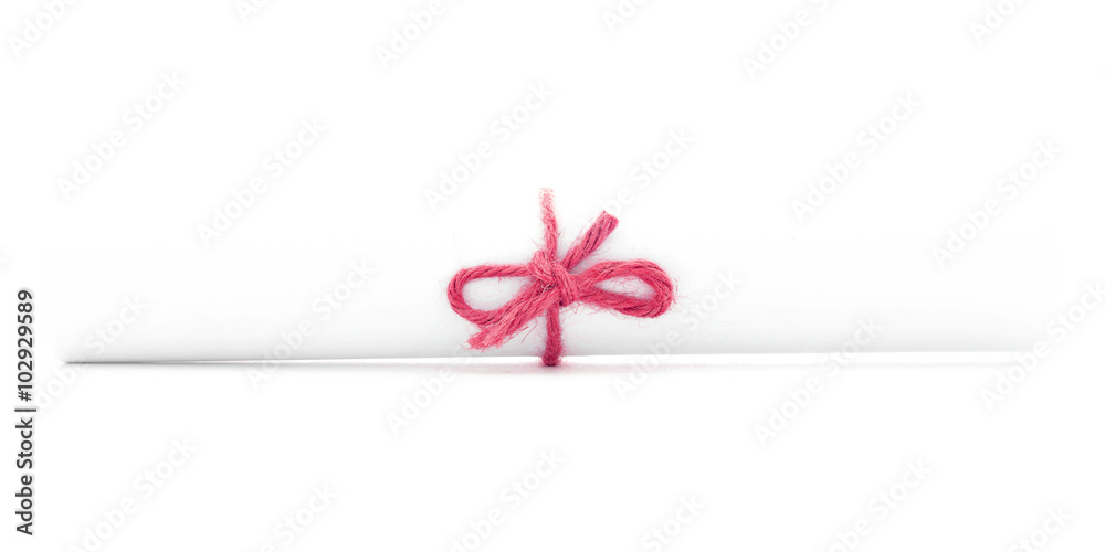 White letter scroll tied with rope, single red knot isolated White letter scroll tied with rope, single red knot isolated