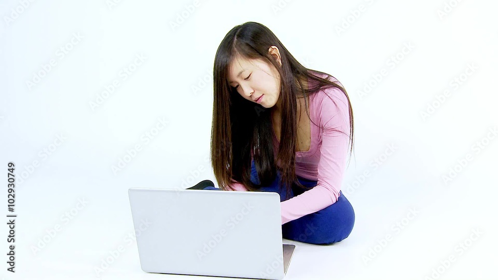 Cute asian woman working with pc sitting on ground isolated Cute asian woman working with pc sitting on ground isolated