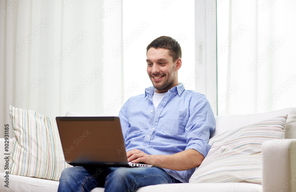 smiling man working with laptop at home