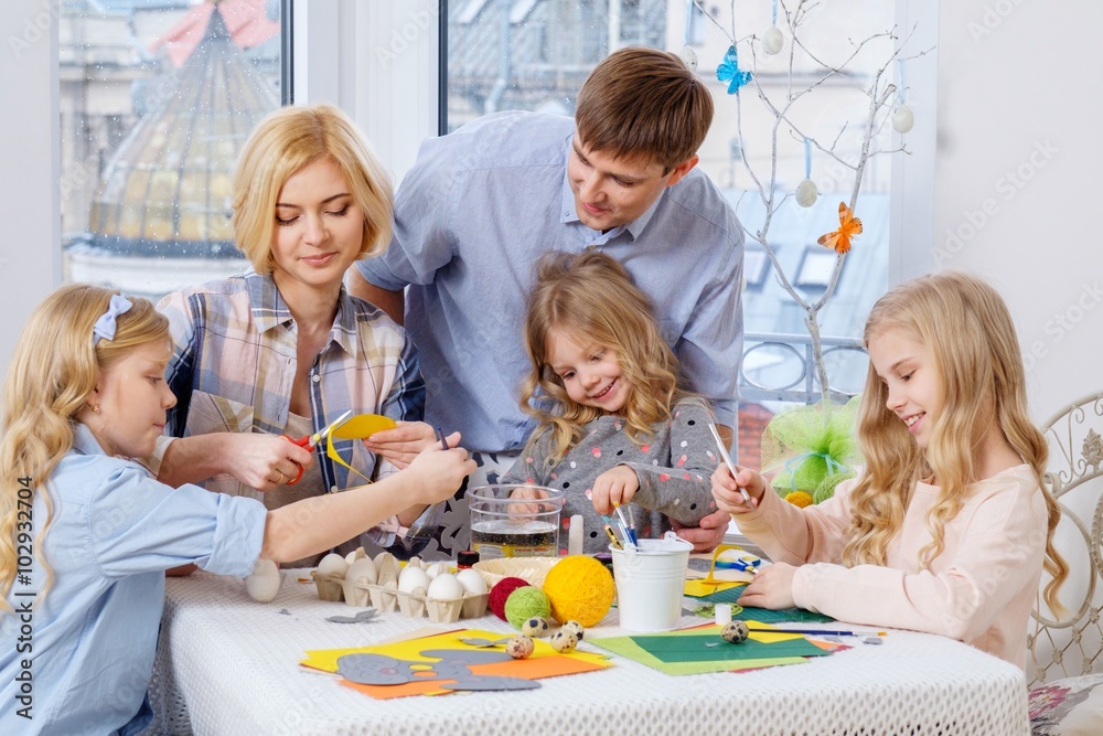 Cheerful family having fun painting and decorating easter eggs. Cheerful family having fun painting and decorating easter eggs.