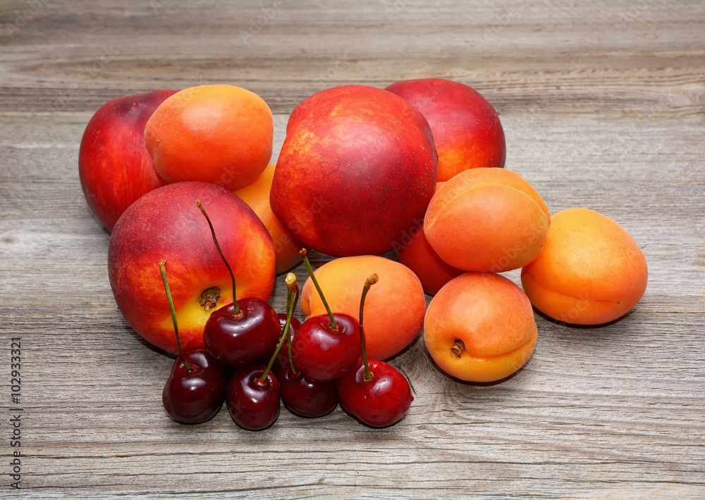 Nectarines, cherries and apricots on wooden table Nectarines, cherries and apricots on wooden table