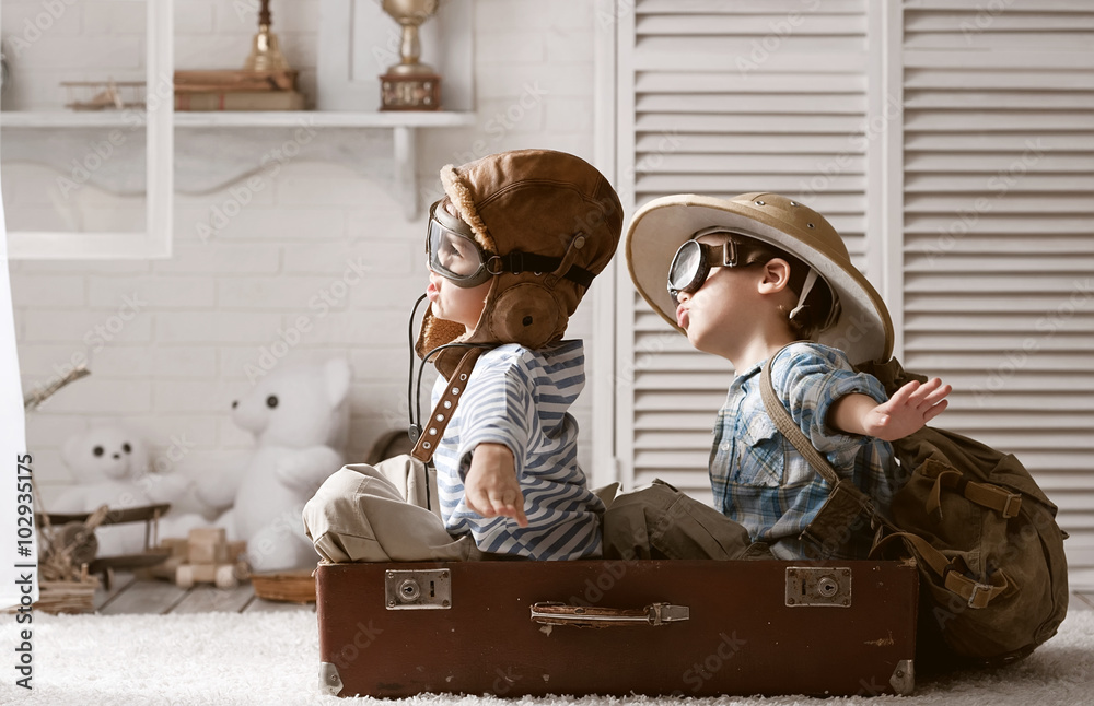 Boys in images traveler and pilot play in his room - obrazy, fototapety, plakaty 