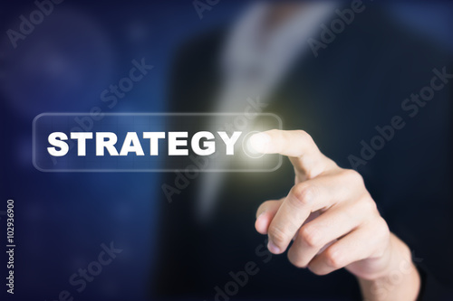 Businessman pressing a STRATEGY concept button. Can be used in advertising.