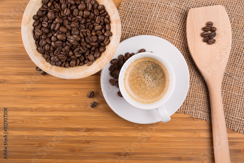 Coffee beans in bowl on wooden background © Kovac Mario
