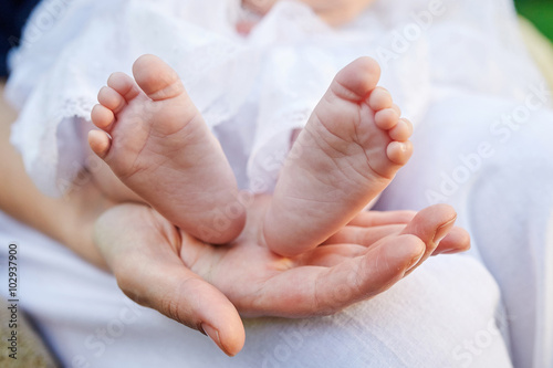 mother hand holding small baby feet