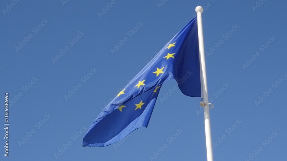 Fabric of European Union recognizable flag waving in front of blue sky ...