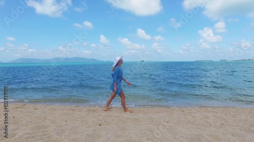 Young beautiful women in the blue on the sunny tropical beach photo