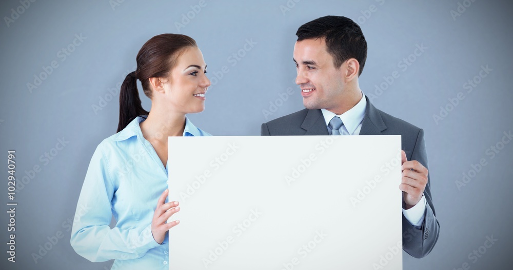 Composite image of young business partners presenting sign Composite image of young business partners presenting sign