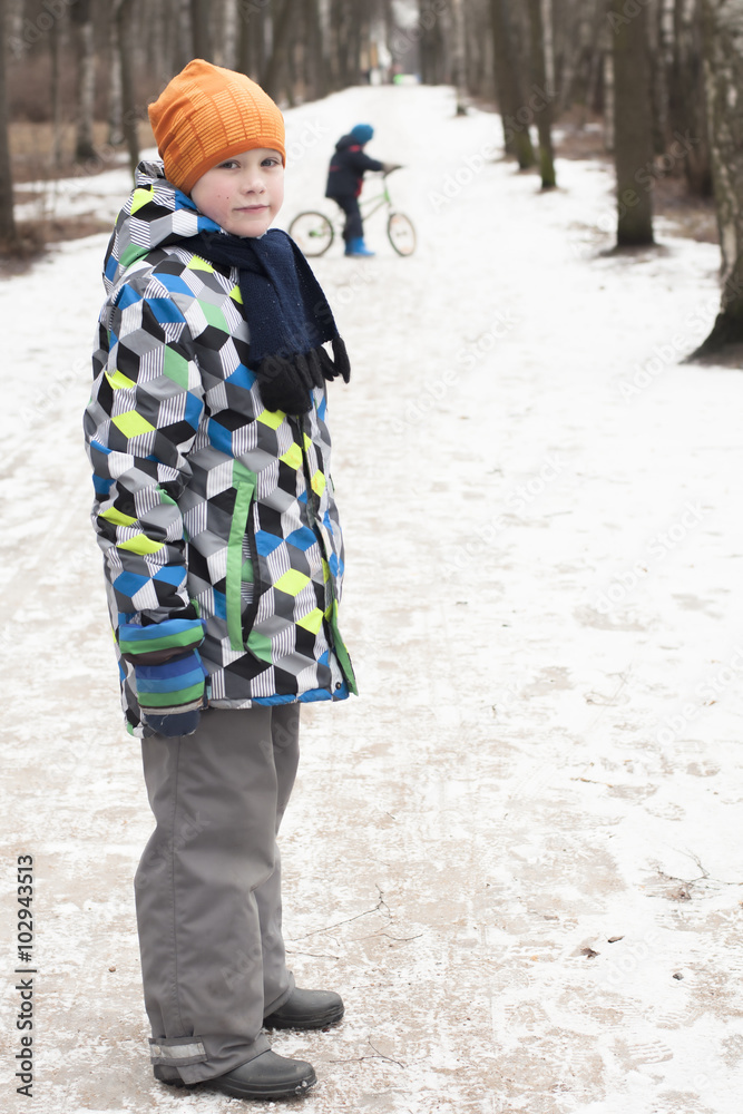 Children walk along a path in a winter park.