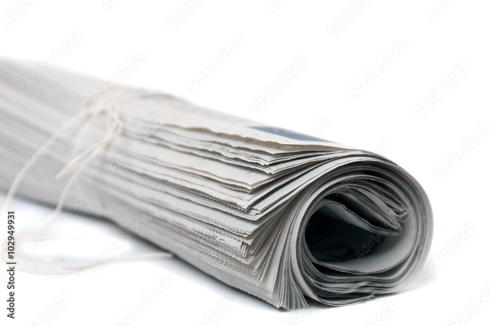 Close view of a rolled up newspaper with string isolated on a white background. Close view of a rolled up newspaper with string isolated on a white background.