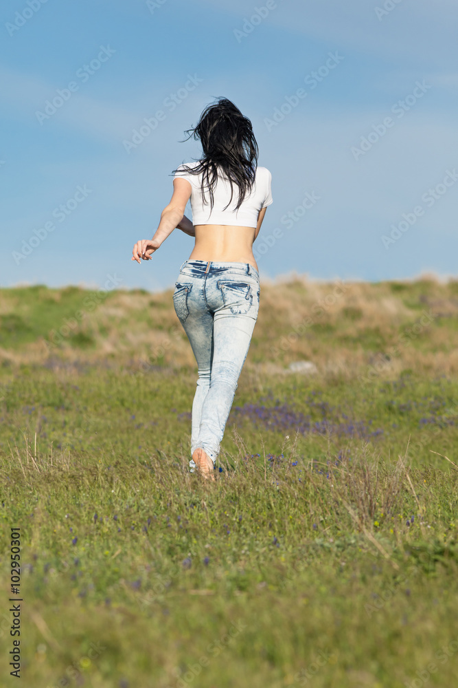 Barefoot girl in jeans is running along field Stock Photo Adobe Stock