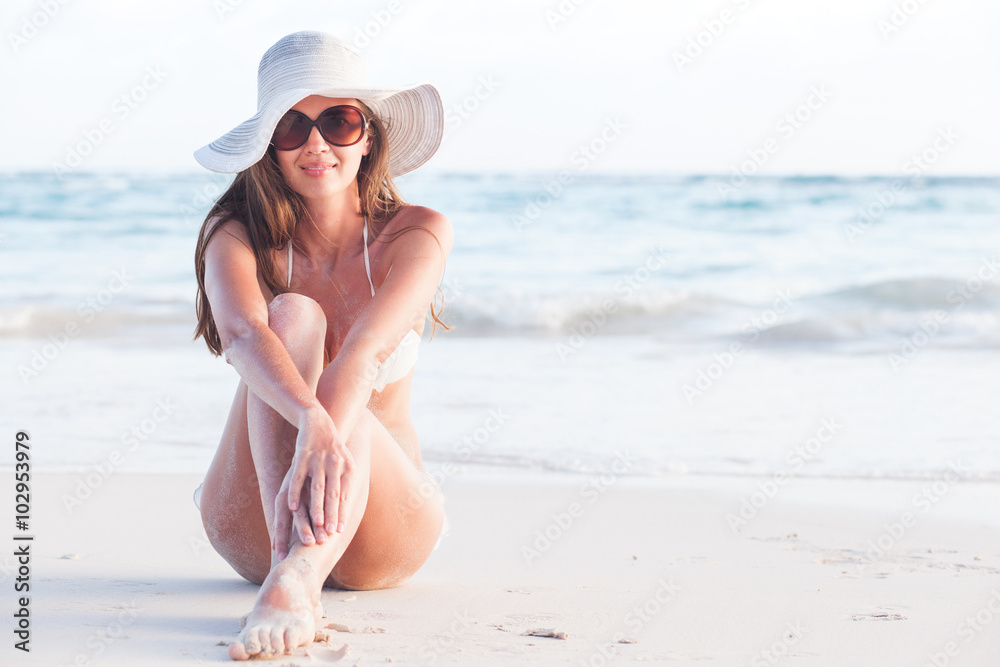 woman in bikini and straw hat lying on tropical beach woman in bikini and straw hat lying on tropical beach