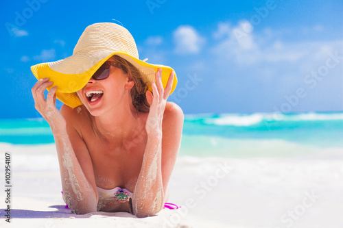 woman in bikini and straw hat having fun on tropical beach