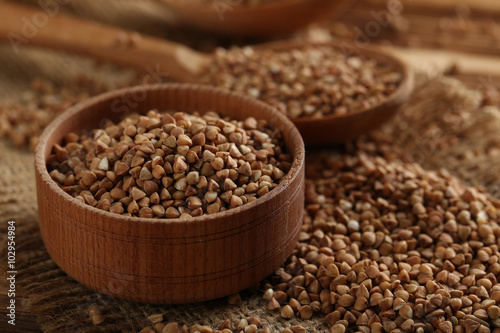 Buckwheat seeds in bowl on a brown wooden table © 5second