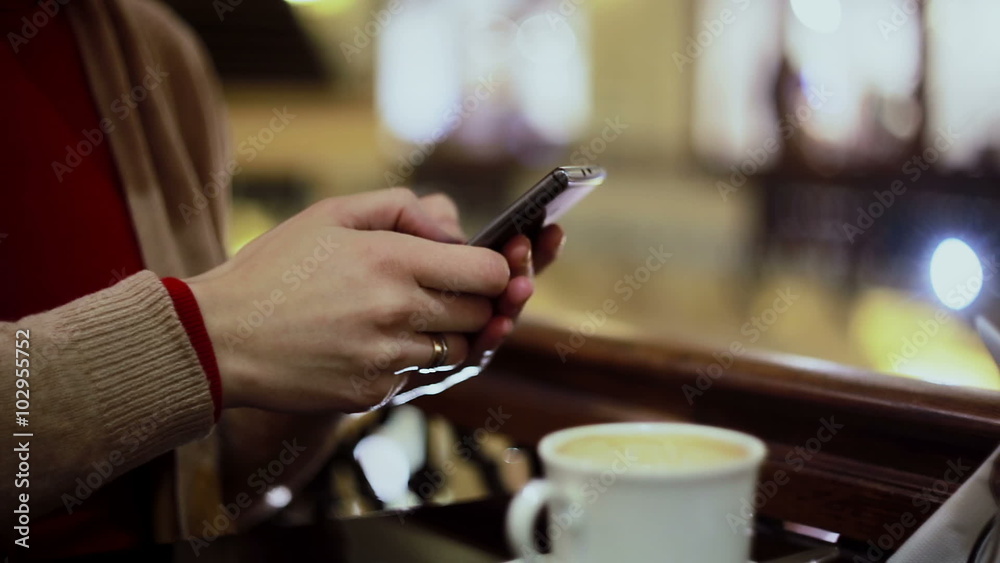 Woman hands texting, using smartphone in cafe. Woman hands texting, using smartphone in cafe.