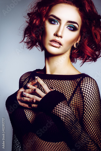 Beautiful gothic girl hipster model with piercings, with red hair, make-up art in black svitshote in the studio photo