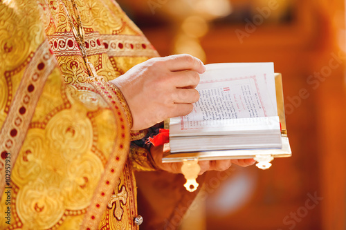 Vászonkép Prayer book in the hands of the priest