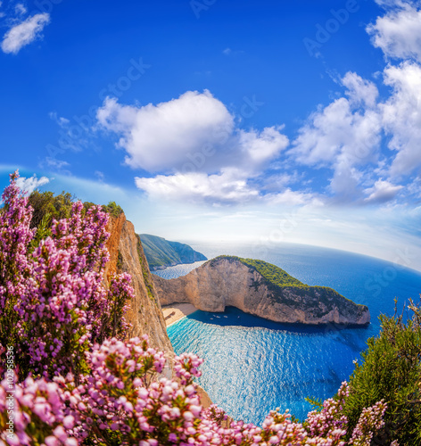 Navagio beach with shipwreck and flowers against blue sky on Zakynthos island, Greece