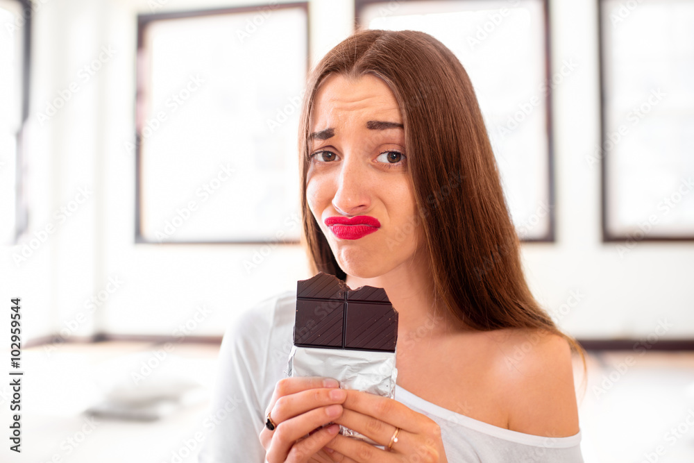 Woman with disappointed emotions holding chocolate Woman with disappointed emotions holding chocolate