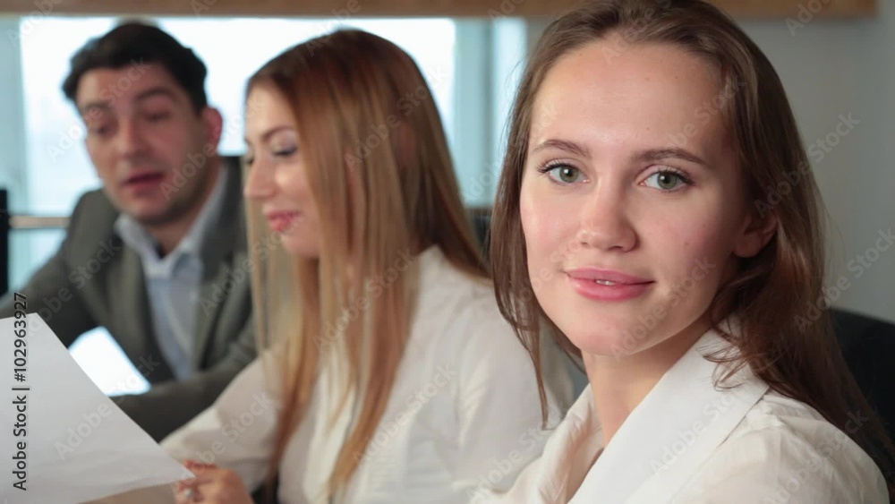 three people work in the office one of the girls looking at the camera three people work in the office one of the girls looking at the camera