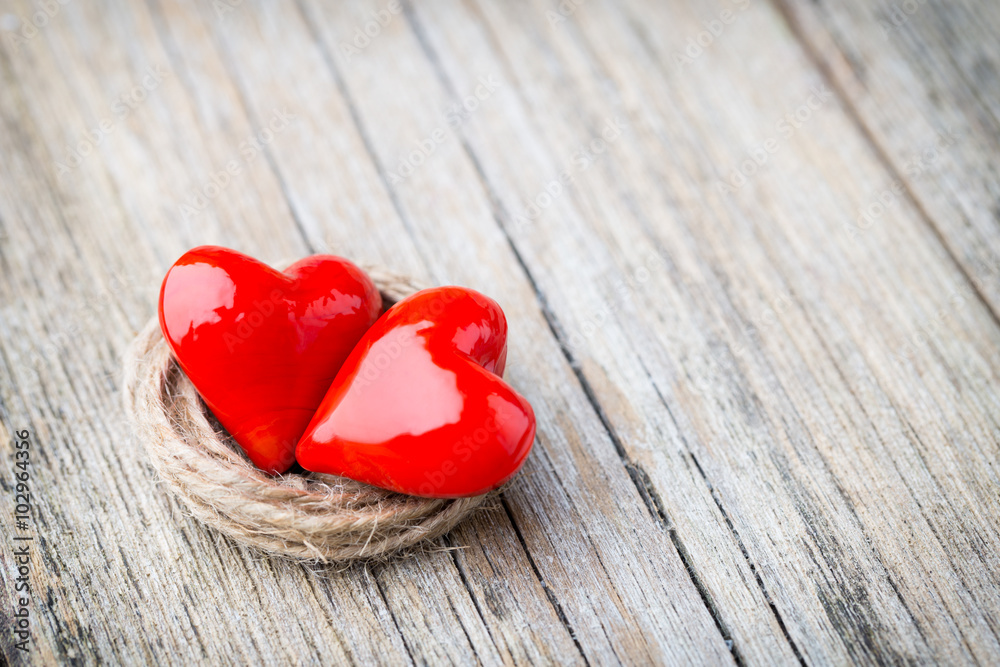 Two red heart-shaped on a wooden background. Two red heart-shaped on a wooden background.