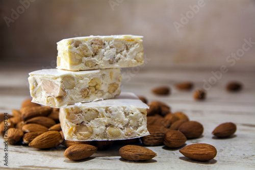 Torrone or nougat and almonds on a rustic wooden table, close up photo