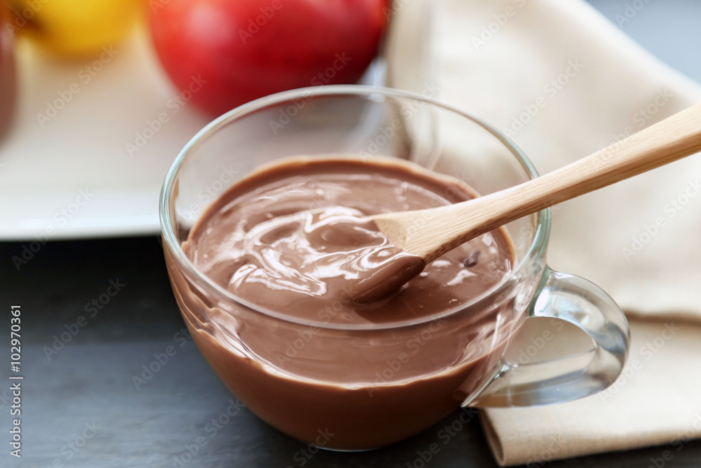 Melted chocolate in bowl, on wooden background Melted chocolate in bowl, on wooden background