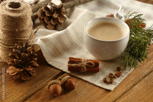 Cup of coffee on napkin on wooden background