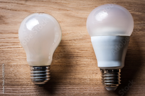 incandescent and LED lamp on wooden table photo