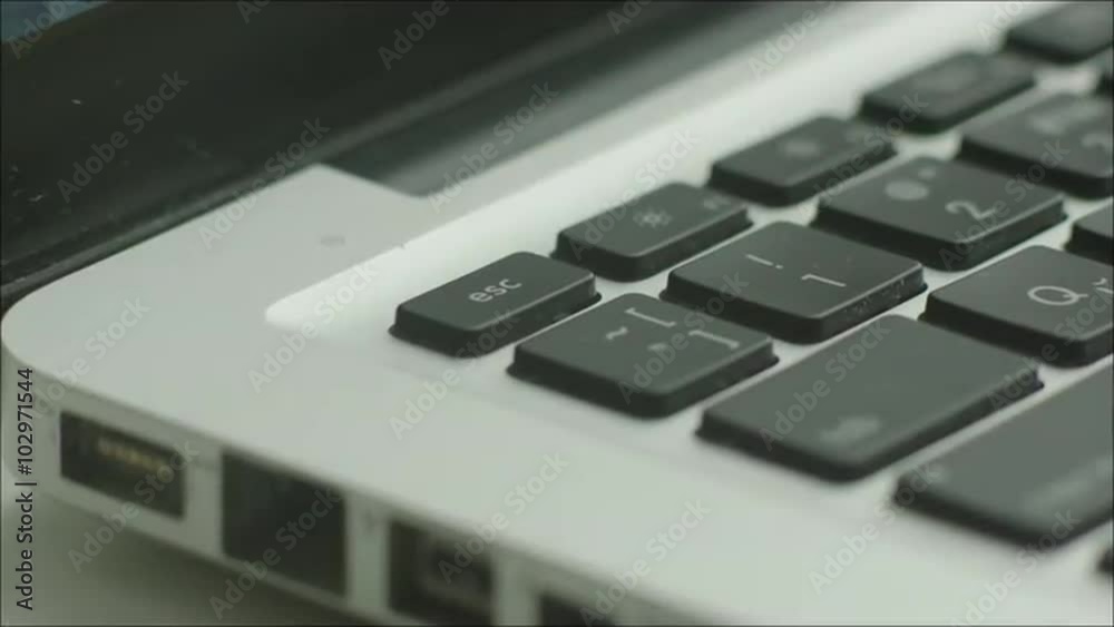 Man Pressing Escape Button on Laptop Man Pressing Escape Button on Laptop