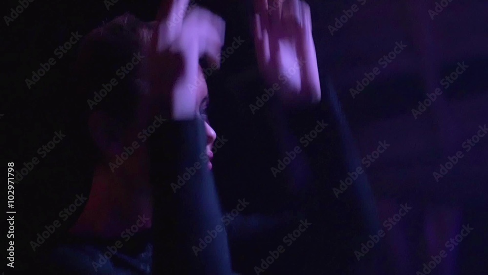 Dj girl in top use hands as guns, dance at turntable in nightclub. Slow motion