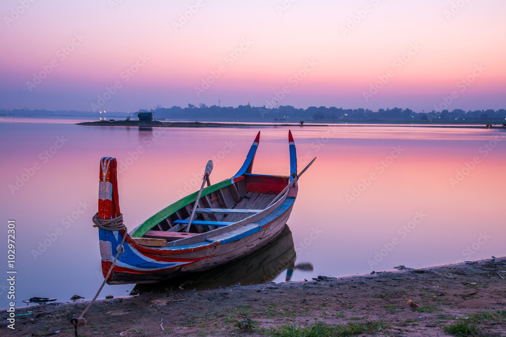 Fishing boat in sunrise at U Bein bridge, Mandalay, Myanmar