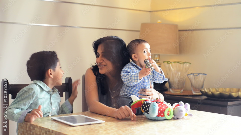 Locked-on shot of a woman using digital tablet with her son at home Locked-on shot of a woman using digital tablet with her son at home