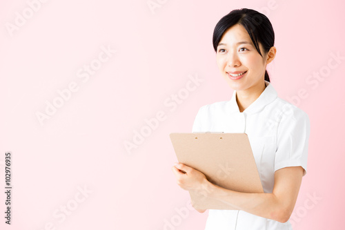 portrait of asian nurse isolated on pink background © taka