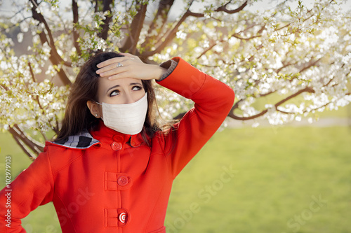 Woman with Allergy with Respirator Mask in Spring Blooming Decor