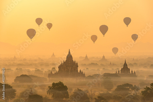 Hot air balloons float over pagodas field