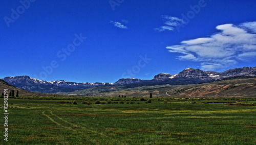 Dubois Wyoming pasture / farming field under cumulus / cirrus cloudscape with Absaroka Mountain range in the background photo
