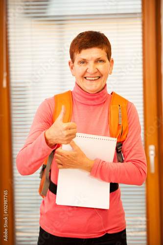 Obraz na plátně Older woman representing lifelong learning. Woman with school ba
