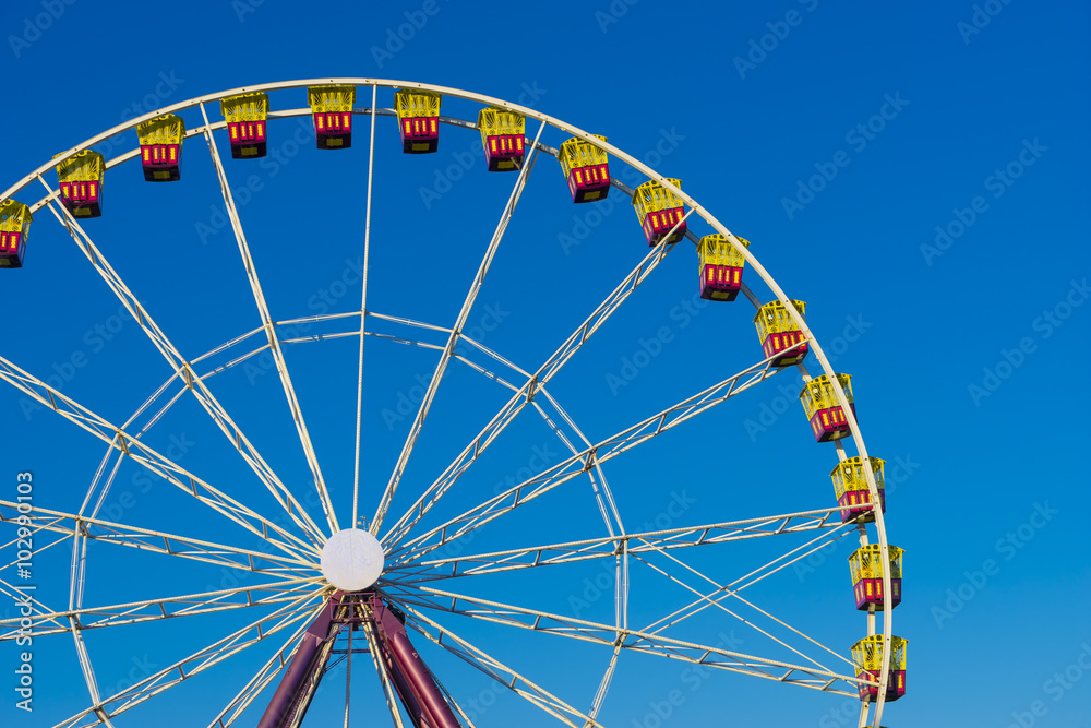 Ferris wheel on the background of blue sky